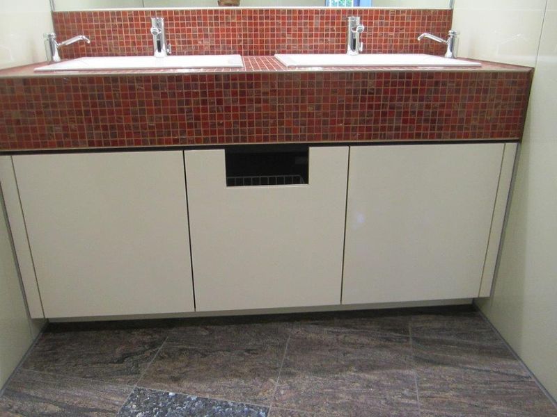 Doppelwaschtisch mit Mosaikfliesen und weißen Unterschränken
