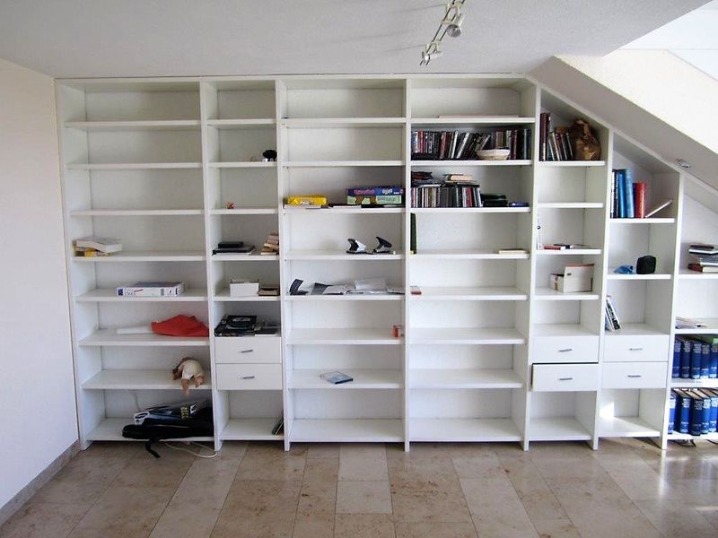 Einbauregal mit offenen Fächern und Schubladen unter einer Dachschräge