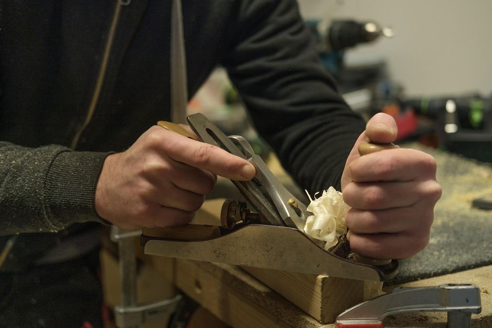 Handwerkliche Holzbearbeitung mit einem Hobel an einer Werkbank